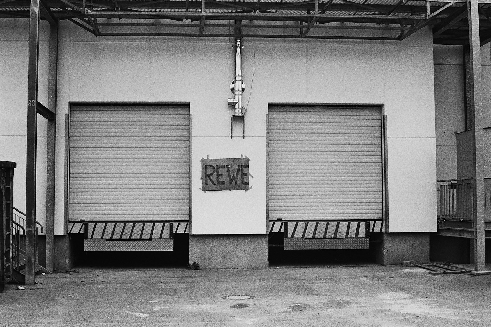 a black and white photo of a building with roller up doors